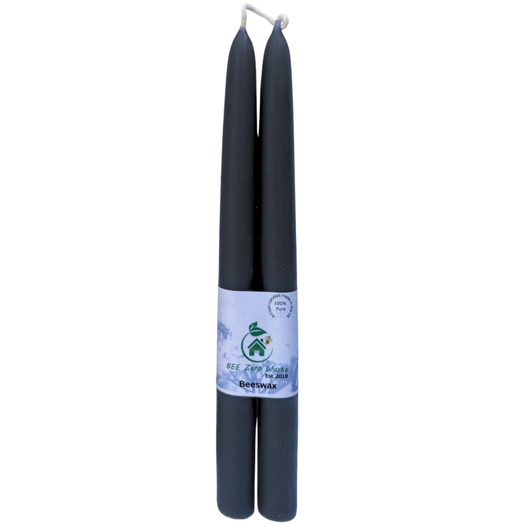 Tall black beeswax taper candles used as natural, eco-friendly centrepieces for a wedding reception table.