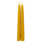 Close-up of the textured surface on hand-dripped beeswax taper candles showing their natural golden honey colour.